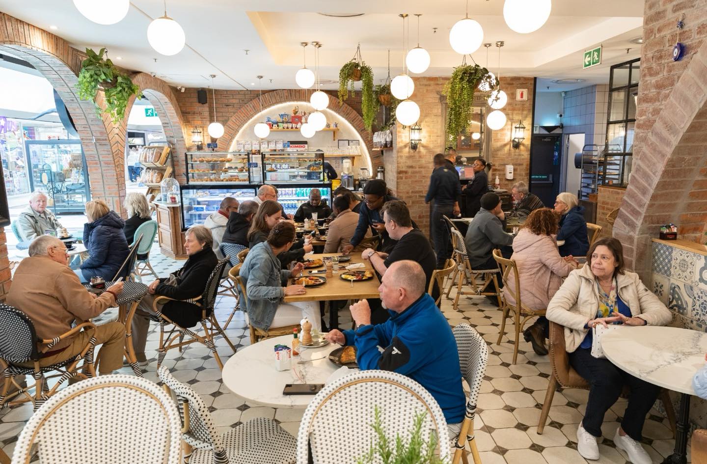 The Crossley & Sons café interior — brick arches, pendant lights, customers